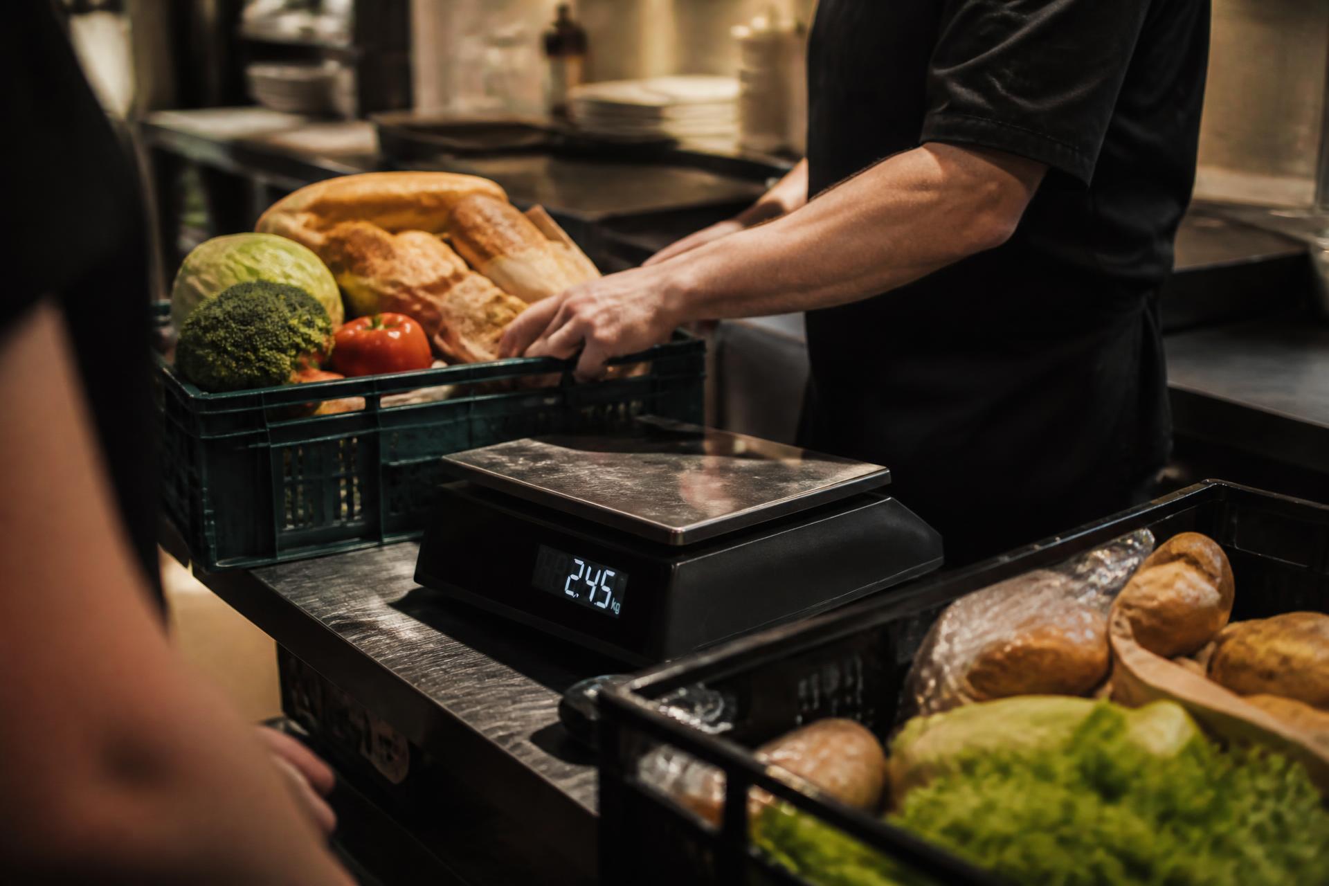 Cocina pesando excedente de alimentos en una báscula digital